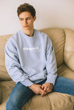 Load image into Gallery viewer, Male model sitting on sofa modelling blue conscious collection sweatshirt