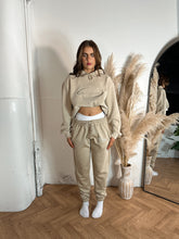 Load image into Gallery viewer, Female standing in a studio modelling cream tracksuit
