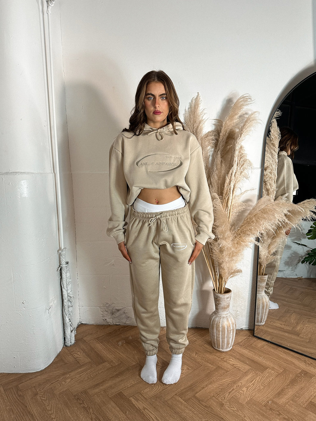 Female standing in a studio modelling cream tracksuit