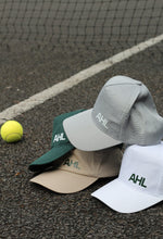 Load image into Gallery viewer, Grey, khaki, white and cream AHL caps on tennis court with tennis ball and net in the background
