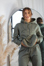 Load image into Gallery viewer, Female standing in front of a mirror modelling khaki tracksuit
