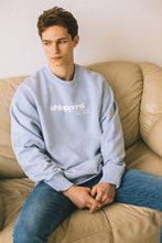 Load image into Gallery viewer, Male model sitting on sofa modelling blue conscious collection sweatshirt
