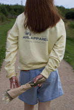 Load image into Gallery viewer, Serene Butter unisex crew neck sweatshirt with AHL Apparel Fresh Start graphic
