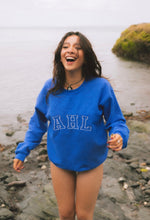 Load image into Gallery viewer, Female modelling blue signature sweatshirt on a beach
