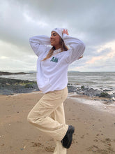 Load image into Gallery viewer, Female modelling white beanie and hoodie on a beach
