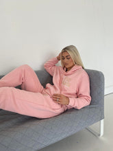 Load image into Gallery viewer, Female lying on sofa modelling pink stay golden tracksuit
