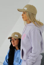 Load image into Gallery viewer, Two females modelling purple and blue tracksuit whilst wearing cream caps
