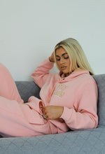 Load image into Gallery viewer, Female lying on sofa modelling pink stay golden tracksuit
