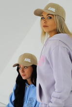 Load image into Gallery viewer, Two females modelling blue and purple tracksuits whilst wearing cream caps
