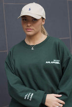 Load image into Gallery viewer, Female modelling green MWC sweatshirt
