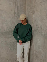 Load image into Gallery viewer, Female modelling green MWC sweatshirt
