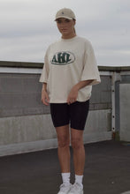 Load image into Gallery viewer, Model wearing Natural Raw oversized graphic T-shirt with green AHL print
