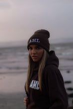 Load image into Gallery viewer, Female modelling brown hoodie and beanie on a beach
