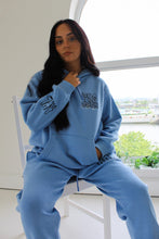 Load image into Gallery viewer, Female sitting on chair wearing blue sea you soon tracksuit
