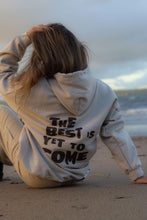 Load image into Gallery viewer, Female sitting on beach wearing cream the best is yet to come hoodie
