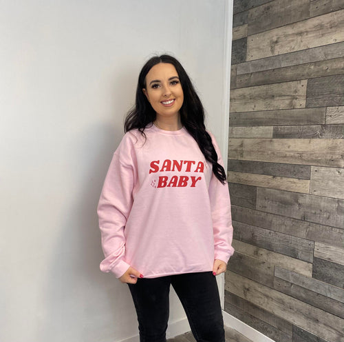 Female wearing pink Santa Baby sweatshirt